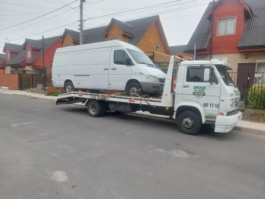 Traslado de furgón blanco en grúa plataforma