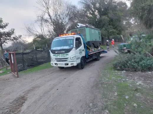 Grúa Cofré en camino rural con carga